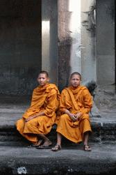 Two Buddhist monks smile for a photo op in Angkor Wat