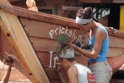 Volunteers paint the insignia of the club or person who donated the making of the boat.