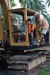 Scott teaches Peter and Paul how to operate a front end loader.