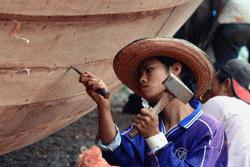 Local workers were paid to do specific and technical tasks in boat building. This person is chaulking the boat.