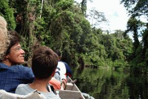 Therese enjoys the peaceful boat ride on the Sungai Tahan with the forest canopy looming over the river.