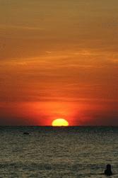 The morning sun breaks the horizon on Koh Samet island.