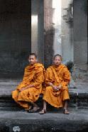 Two Buddhist monks smile for a photo op in Angkor Wat