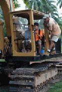 Scott teaches Peter and Paul how to operate a front end loader.