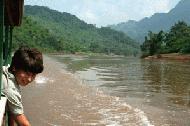 Paul waves and yells Sawbadee (hello) to kids along the river bank