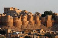 The fort, which springs out of the desert, is surrounded by honey colored buildings of this small town.